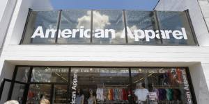 Passers-by walk down the street past the American Apparel store in the Shadyside neighborhood of Pittsburgh on Wednesday, July 9, 2014. American Apparel Inc. has reached a preliminary deal with investment firm Standard General to receive $25 million in financing to bolster the clothing chains finances, according to a person close to the negotiations.(AP Photo/Keith Srakocic)