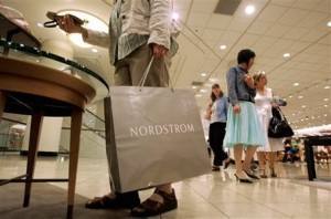 A shopper looks over a shoe display as others walk past in the women's shoe department of the downtown Seattle Nordstrom store, Wednesday, May 17, 2006. Nordstrom Inc. releases first-quarter earnings. (AP Photo/Elaine Thompson)