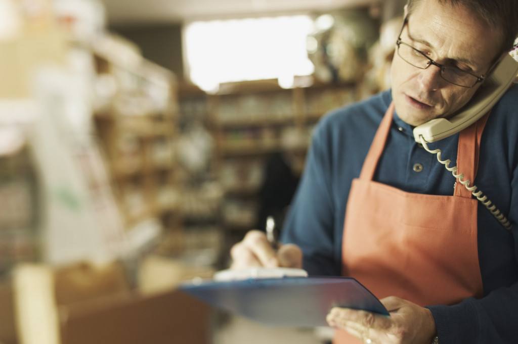 Clerk writing on clipboard in store