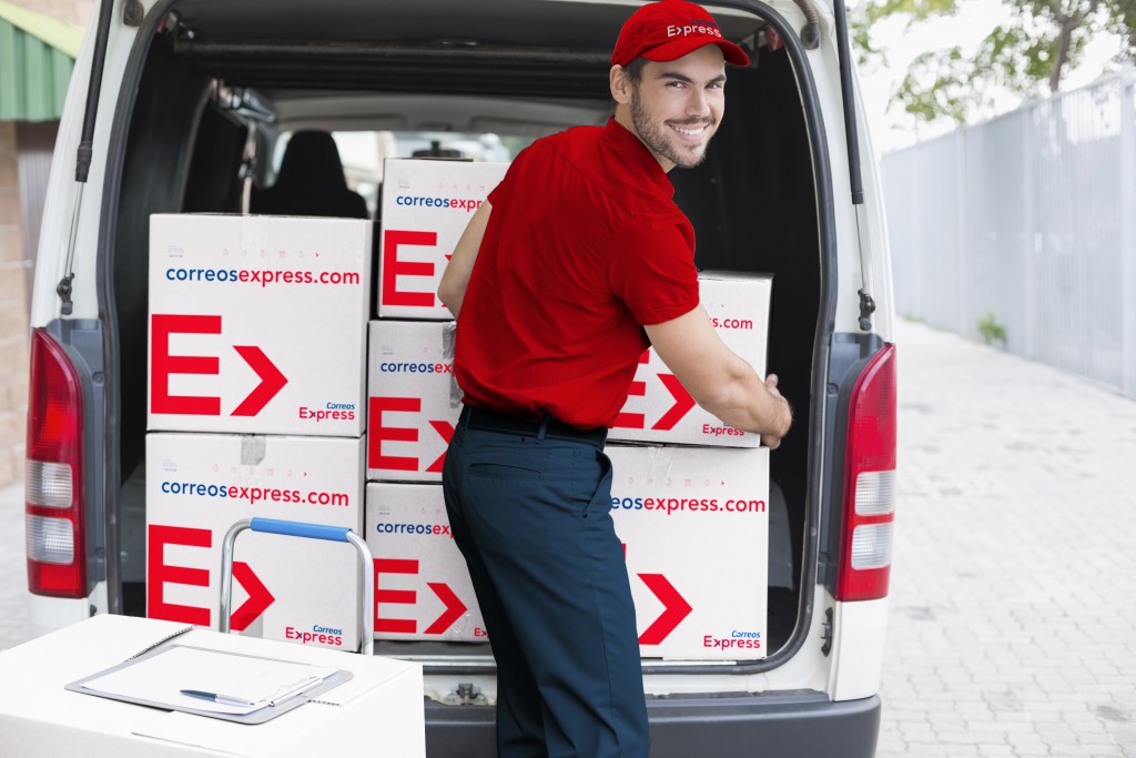 Delivery driver loading his van with boxes